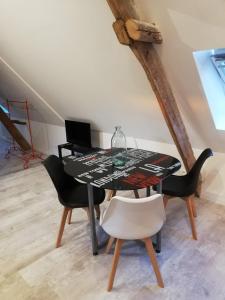Flines-lès-Mortagne的住宿－Au cochon qui rit，一间用餐室,配有黑色的桌子和椅子