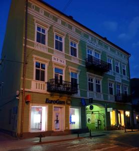 a building that is lit up at night at Sissy Vendégház in Tîrgu Secuiesc