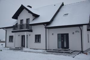 una casa blanca con nieve en el techo en Noclegi u Eweliny, en Krajno Pierwsze