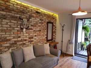 uma sala de estar com uma parede de tijolos e um sofá em Apartamenty 33 em Zakopane