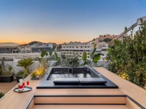 a rooftop patio with a hot tub on a balcony at The Newel Acropolis in Athens