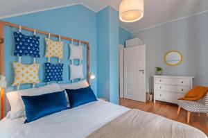 Schlafzimmer mit blauen Wänden und einem Bett mit blauen Kissen in der Unterkunft Wiselka Holiday House-1,2km to the beach; 5 bedrooms, 3 bahrooms; fire place. Private sauna! in Wisełka