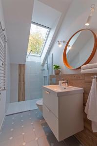 uma casa de banho com um lavatório, um chuveiro e um espelho. em Wiselka Holiday House-1,2km to the beach; 5 bedrooms, 3 bahrooms; fire place. Private sauna! em Wisełka