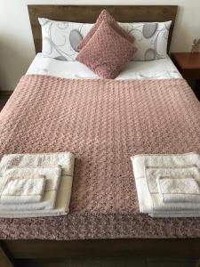 a bed with a pink blanket and pillows on it at Excellent studios for your vacation-Hotel Villa Park- Borovets in Borovets