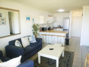 sala de estar con sofá y mesa en Cape Town Family Beachfront Apartment Leisure Bay en Ciudad del Cabo