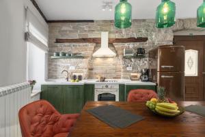 una cocina con armarios verdes y una mesa con un bol de fruta en Apartman Pisino**** 70m2, 2+2, en Pazin