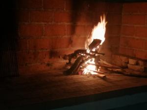 a brick fireplace with a fire in it at Apartments Bako Komiza in Komiža
