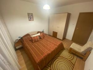 a small bedroom with a bed and a chair at Nevena Apartments in Bansko