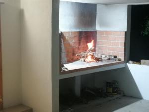 a brick fireplace with a fire in it at Apartments Bako Komiza in Komiža