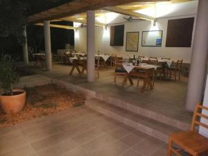 eine Terrasse mit Tischen und Stühlen in einem Restaurant in der Unterkunft Apartments Bako Komiza in Komiža