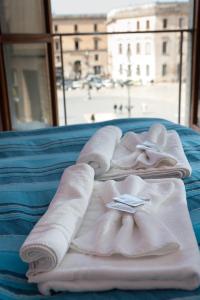 a pile of towels sitting on top of a bed at Leccesalento Bed And Breakfast in Lecce