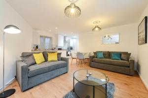 a living room with two couches and a table at The Zone - Vibrant City Centre Apartment in Nottingham