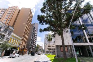 uma rua da cidade com uma árvore e edifícios em Hotel Dan Inn Curitiba Centro em Curitiba
