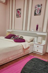 a bedroom with a white bed and a pink rug at Apartmani RALE rooms in Sarajevo