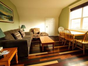 uma sala de estar com um sofá e uma mesa em James Bay Inn Hotel, Suites & Cottage em Victoria