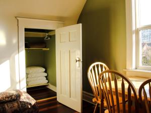 uma sala de jantar com paredes verdes e uma mesa e cadeiras em James Bay Inn Hotel, Suites & Cottage em Victoria