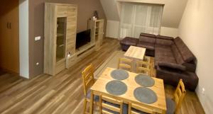 a living room with a table and chairs and a couch at BarAnd Apartman in Eger