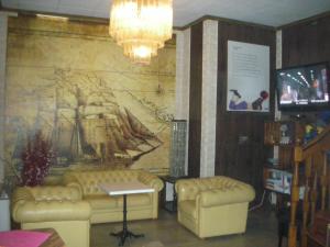Hotel Total في بيسوني: غرفة بها أريكتين ولوحة على الحائط