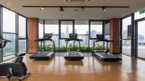 a gym with several treadmills and large windows at Ceylonz Suites Kuala Lumpur, Roam in Kuala Lumpur