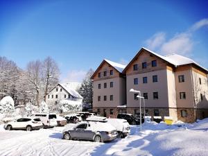 un gruppo di auto parcheggiate in un parcheggio coperto di neve di Sunny apartmán Deštné 3+kk a Deštné v Orlických horách