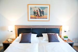 een slaapkamer met twee bedden en een schilderij aan de muur bij Ferienwohnung Meeresrausch in Westerland