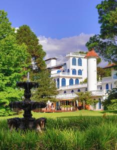 a fountain in front of a large white building at Hotel Gramado Palace in Gramado