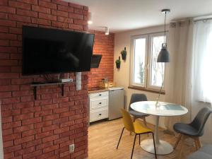 a living room with a brick wall and a table with chairs at Apartamencik - Kowary in Kowary