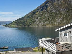 ein Haus am Ufer eines Sees mit einem Berg in der Unterkunft 4 person holiday home in Selje in Selje