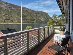 een balkon met een tafel en stoelen en uitzicht op een meer bij 4 person holiday home in Selje in Selje