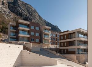 an apartment building in front of a mountain at Bonintro Lux Apartment in Kotor