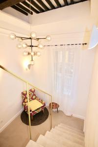 een kamer met een trap en een kroonluchter bij Le Madeleine (duplex) in Aix-en-Provence