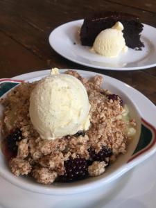 a plate of blackberry cobbler with ice cream on top at Highland Moors in Llandrindod Wells