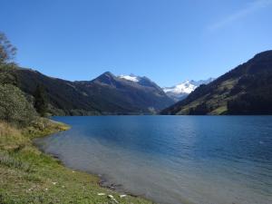 a view of a lake with mountains in the background at Berghotel Der Königsleitner - Adults only in Königsleiten