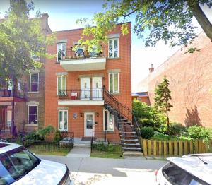 a brick building with a staircase in front of it at Maison Montplaisir in Montreal