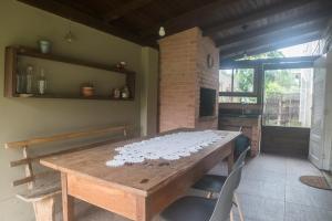 comedor con mesa de madera y chimenea en Casa de Praia Florianópolis, en Florianópolis