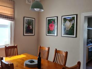 奧蘭治的住宿－Arden on McLachlan，一间用餐室,配有一张桌子和四张墙上的照片