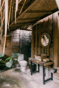 baño con aseo y pared de madera en Wooden house at Semadi living en Sukawati