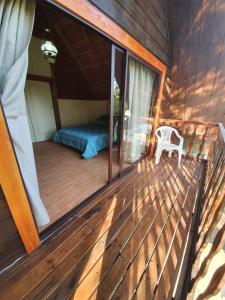 a room with a bed on a wooden deck at cabaña los robles in Licán Ray