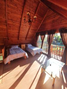 Zimmer im Dachgeschoss mit 2 Betten und einem Kronleuchter in der Unterkunft cabaña los robles in Licán Ray