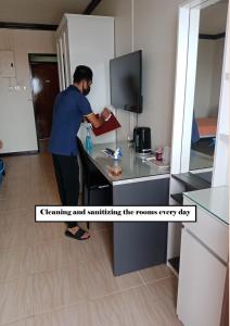 a man standing at a desk in a room at Witchuwan Apartel in Bangkok