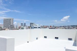 uitzicht op de stad vanaf het dak van een wit gebouw bij Kokusai Street Garden Hotel -SEVEN Hotels and Resorts- in Naha