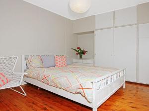 a bedroom with a white bed and a chair at Culburra Sands in Culburra Beach