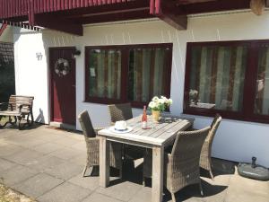 a wooden table and chairs on a patio at Holiday home in Reimboldshausen with balcony in Kemmerode