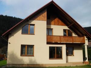 a large house with a balcony on top of it at Apartmány u Samuela in Oravský Biely Potok