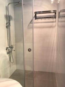 een douche met een glazen deur in de badkamer bij SAOLA Apartment Le Chan Hai Phong in Hoàng Mai