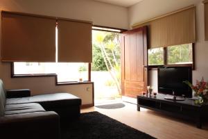 a living room with a couch and a television at Guesthouse Pool & Sea Espinho Oporto in Espinho