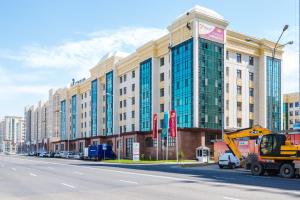a large building on the side of a city street at Sulu Hostel in Astana