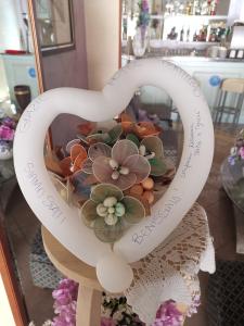 un mazzo di fiori a forma di cuore in una finestra esposta di Hotel Marittimo a Rimini