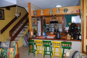 a kitchen with yellow and green chairs and a counter at Casa Mariluz in Agaete