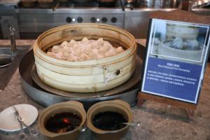 un barril de comida en una mesa junto a una señal en Hyatt Regency Wuxi en Wuxi